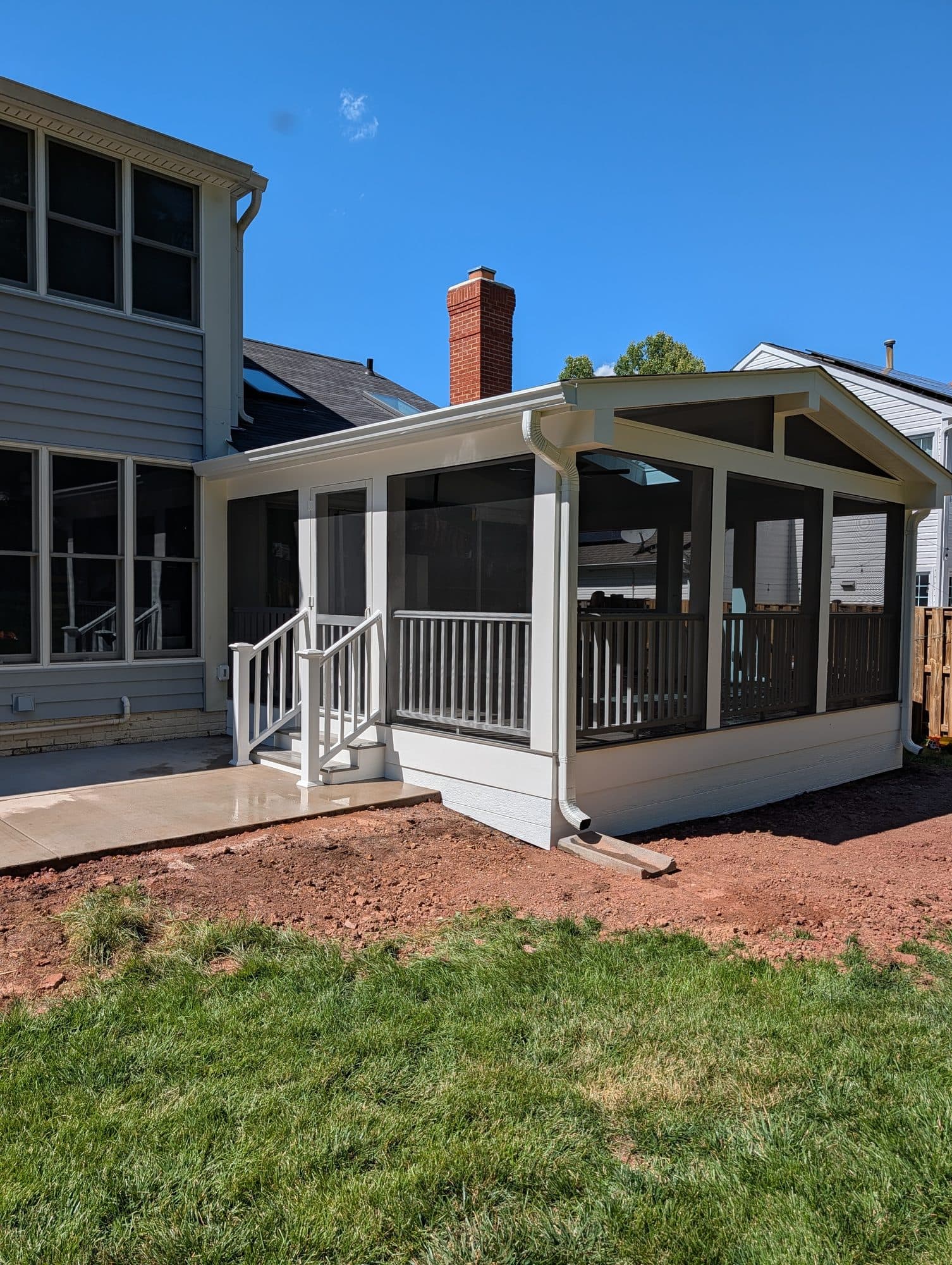 Wide exterior view of a home with a newly built screened-in porch