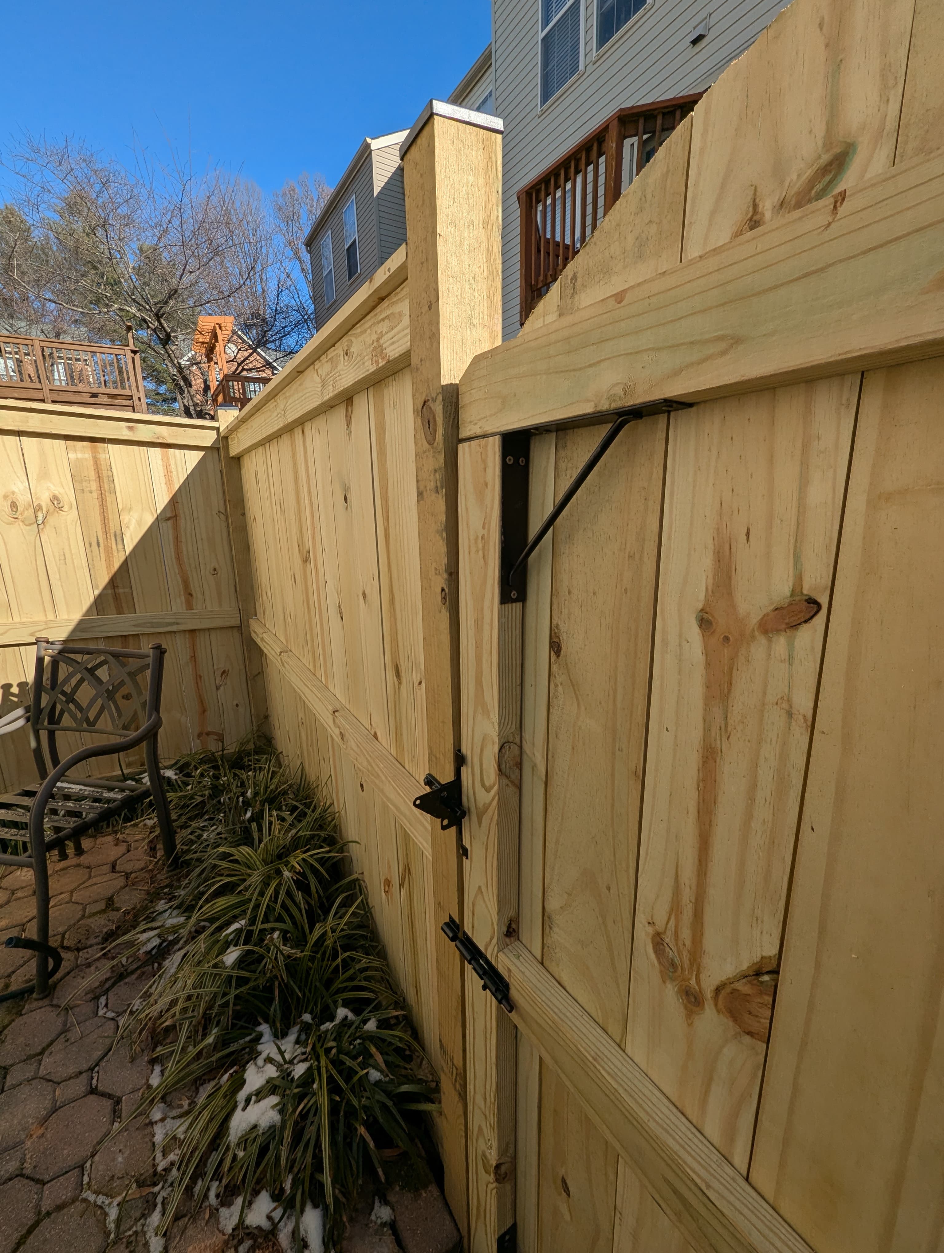 Wood privacy fence with gate along a backyard patio
